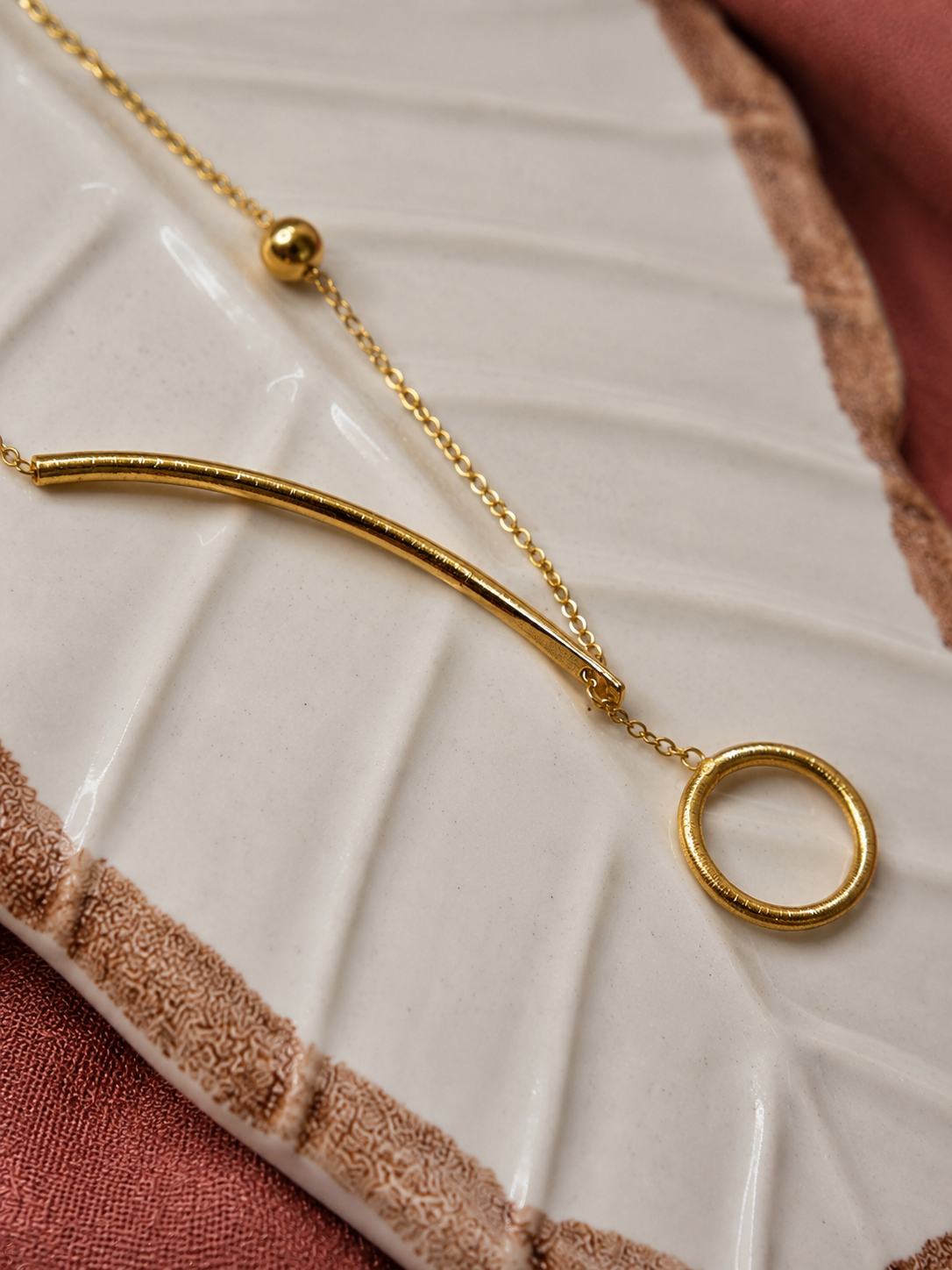 Gold bracelet with a unique design on a textured white surface